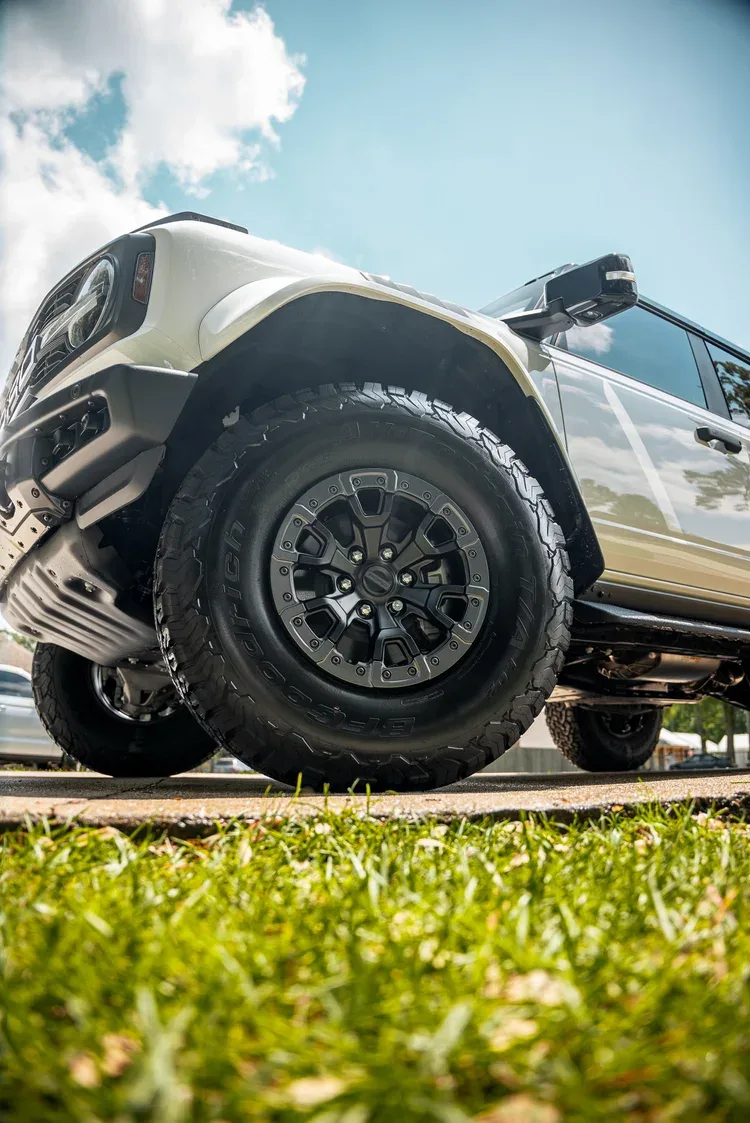 Low-angle view of a cleaned wheel, tire, and white SUV bodywork